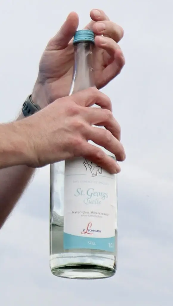 Nahaufnahme davon, wie eine Flasche St. Georgsquelle still geöffnet wird