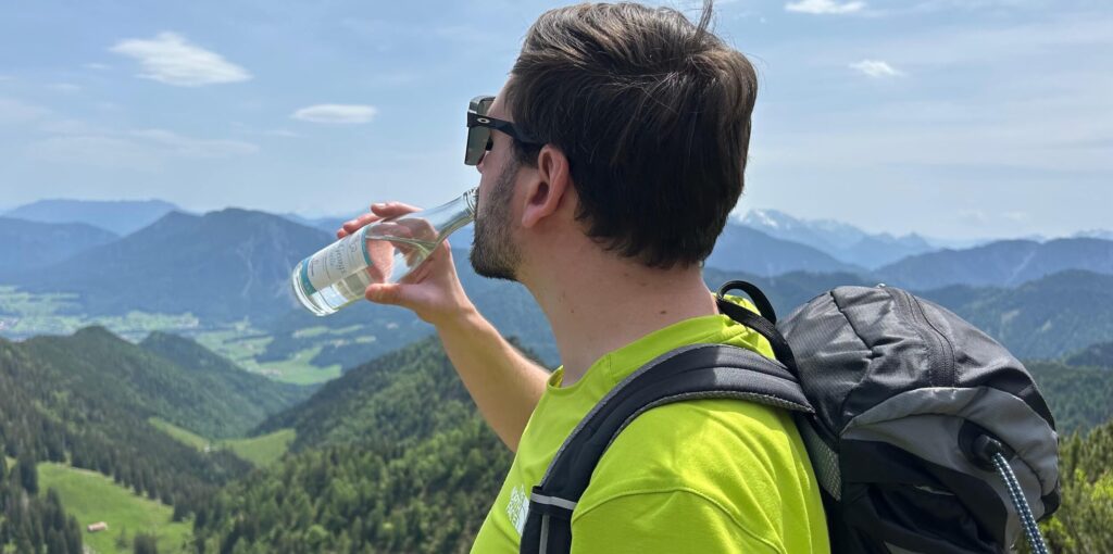 Wanderer trinkt auf Berg aus 0,33-Liter-Flasche St. Georgsquelle still