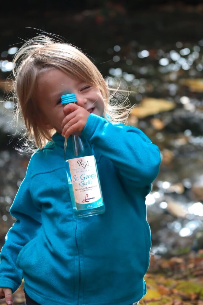 Junge hält kleine 0,33-Liter-Flasche St. Georgsquelle still